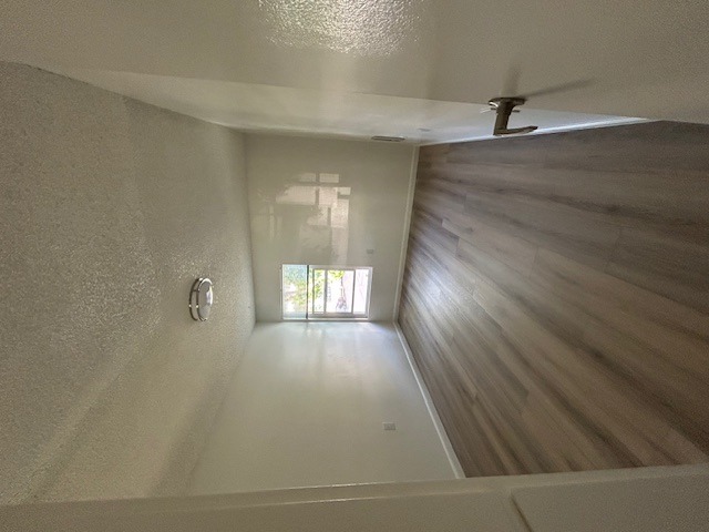 A room with a ceiling fan and a window.